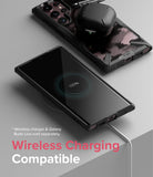 Galaxy S22 Ultra Case | Fusion-X - Galaxy S22 Ultra in a black case charging wirelessly with earbuds resting on top.