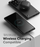 Galaxy S22 Ultra Case | Onyx - Black phone case on a wireless charger with earbuds resting on the back.