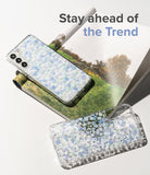 Galaxy S22 Plus Case | Fusion Design - Two clear phone cases with blue floral patterns resting on an open magazine.