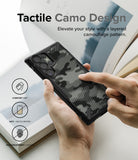 Galaxy S23 Ultra Case | Fusion-X - Hands holding a black phone case with a tactile, layered camouflage pattern.