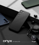 Galaxy S23 Case | Onyx - A textured black phone case for Galaxy S23 resting on a dark, geometric surface with accessories.
