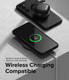 Galaxy S23 Plus Case | Onyx - Black phone case on a wireless charger with a charging icon and earbuds case nearby.
