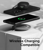 Galaxy S24 Ultra Case | Onyx - Black phone in case wirelessly charging on a circular pad with earbuds in the background.