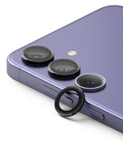 Galaxy S24 Lens Protector | Camera Lens Frame Glass - Galaxy S24 Lens Protector - Black circular lens frame protector resting near the triple camera array of a purple phone.