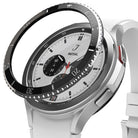 Galaxy Watch 4 Classic 42mm | Bezel Styling - A black adhesive bezel ring hovering above a silver smartwatch with a white band.