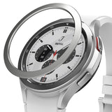 Galaxy Watch 4 Classic 46mm | Bezel Styling - Galaxy Watch 4 Classic 46mm - A silver metal bezel ring hovering above a white smartwatch with a chronograph watch face.