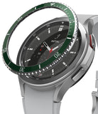 Galaxy Watch 4 Classic 46mm | Bezel Styling - Galaxy Watch 4 Classic 46mm - A green metallic bezel ring hovering above a silver smartwatch with a black analog watch face.