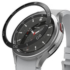 Galaxy Watch 4 Classic 46mm | Bezel Styling - A black adhesive bezel ring hovering above a silver Galaxy Watch 4.
