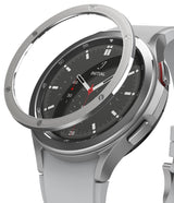 Galaxy Watch 4 Classic 46mm | Bezel Styling - A silver metal bezel ring hovering above a Galaxy Watch 4 Classic with a black face.