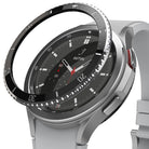 Galaxy Watch 4 Classic 46mm | Bezel Styling - A black adhesive bezel ring hovering above a silver smartwatch face.