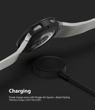 Galaxy Watch 4 44mm | Air Sports Black + Bezel Styling - Smartwatch with protective case hovering over a wireless charger.