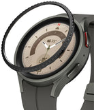 Galaxy Watch 5 Pro 45mm | Bezel Styling - Galaxy Watch 5 Pro 45mm - A black textured bezel ring hovering above a grey smartwatch with a beige analog watch face.