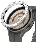 Galaxy Watch 5 Pro (45mm) | Premium Bezel Styling - Galaxy Watch 5 Pro (45mm) - A silver tachymeter bezel ring hovering above a grey smartwatch with a tan watch face.
