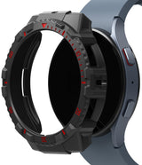 Galaxy Watch 5 / 4 (44mm) Case | Fusion-X - Rugged black protective bezel cover with red accents hovering over a blue smartwatch.