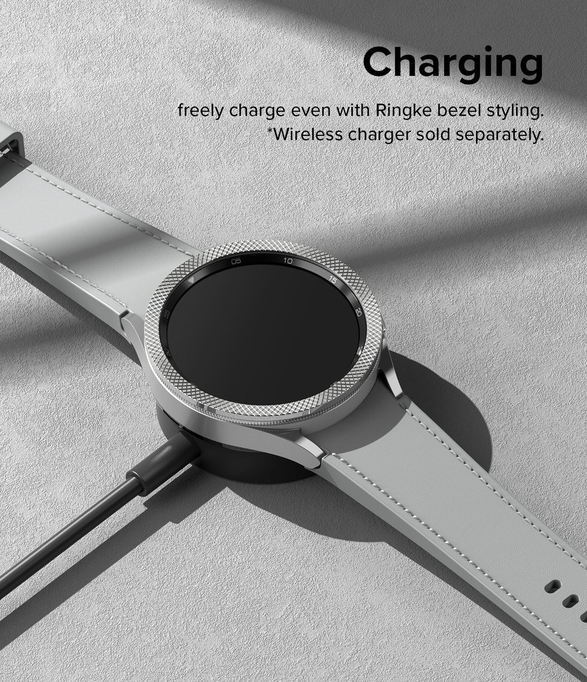 Forerunner 955 | Bezel Styling - Smartwatch with textured silver bezel accessory resting on a wireless charging puck.