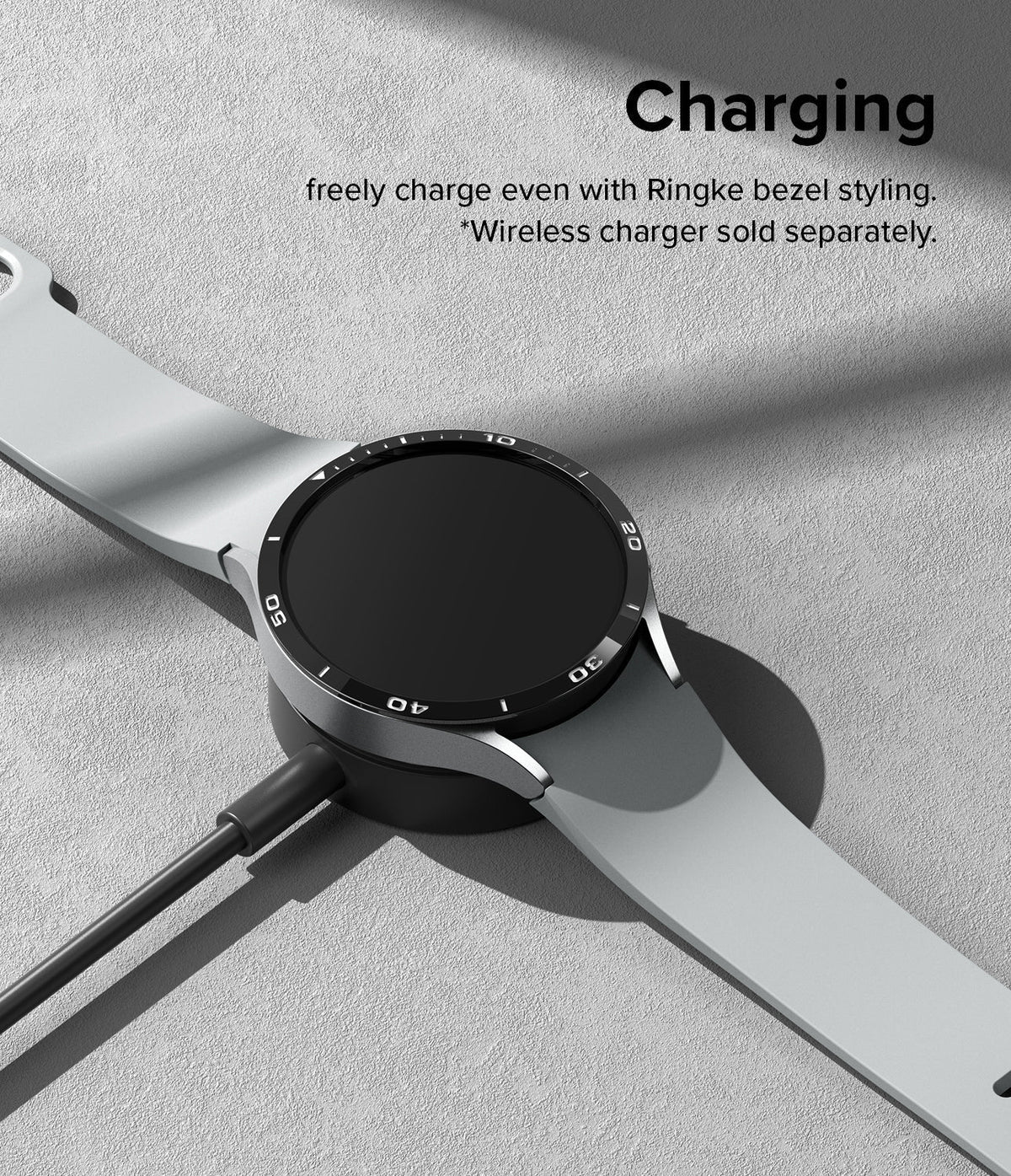 Galaxy Watch 6 44mm | Bezel Styling - A Galaxy Watch 6 with a black bezel accessory charging on a wireless dock.