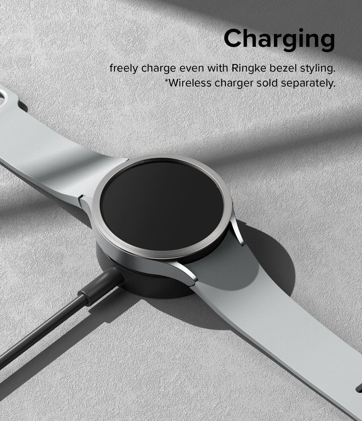 Galaxy Watch 6 44mm | Bezel Styling - A silver Galaxy Watch 6 with a bezel accessory resting on a wireless charging puck.