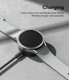 Galaxy Watch 6 44mm | Bezel Styling - A silver Galaxy Watch 6 with a bezel accessory resting on a wireless charging puck.