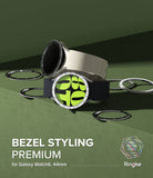 Galaxy Watch 6 (44mm) | Premium Bezel Styling - Two Galaxy Watch 6 units with metallic bezel rings on a green background.