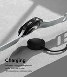 Galaxy Watch 6 44mm Case | Slim - Smartwatch with black protective case hovering above a wireless charging puck.