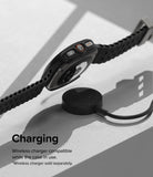 Galaxy Watch Ultra | Slim & Glass - A black smartwatch in a protective case hovering above a wireless charging puck.