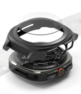 Galaxy Watch Ultra | Slim Extend & Glass - Exploded view of a black protective watch case and screen protector above a Galaxy Watch Ultra.