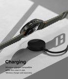 Galaxy Watch 7 (44mm) | Slim & Glass - A Galaxy Watch 7 with an olive green band hovering above a wireless charging puck.
