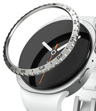 Galaxy Watch 9 / 8 40mm | Bezel Styling - A close-up of a smartwatch with a white band and silver case, showing a clear bezel protector ring with black printed numerals and white hands partially covering the black watch face.