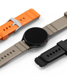 Watch Lug 20mm | Rubber One Bold Band - A smartwatch with a beige band, surrounded by orange and black rubber bands.