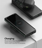 Galaxy Z Fold 3 Case | Slim - Folded phone in black case charging wirelessly with earbuds on top showing 100% battery.