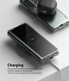 Galaxy Z Fold 3 Case | Slim - Folded phone in a clear case charging wirelessly with earbuds resting on top.