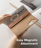 Galaxy Z Fold 7 Cover | Folio Grip Wallet Magnetic - A hand attaching a clear magnetic phone case to a tan leather folio wallet.