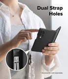 Galaxy Z Fold 8 Case | Onyx Flap Magnetic - A person holds a black foldable phone case with a dangling strap and ring, demonstrating dual strap holes. A circular inset shows the strap attachment detail.