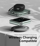 Galaxy Z Flip 5 Case | Slim - Folded phone in clear case charging wirelessly on a pad with earbuds resting on top.
