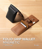 Galaxy Z Flip 7 Cover | Folio Grip Wallet Magnetic - Black phone case and tan leather magnetic wallet with card slot and finger strap on wood surface.
