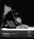 Galaxy Z Flip 7 Case | Onyx Magnetic - Black magnetic phone case on a Galaxy Z Flip 7 charging wirelessly on a rock.