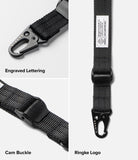 Holder Link Tactical Cam Buckle Hand Strap - Black nylon webbing strap with a black carabiner, shown in a three-panel detail layout highlighting engraved lettering, cam buckle, and ringke logo.