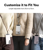 Holder Link Strap | Black - Three people wearing adjustable phone straps with clear cases in different lengths over sweaters.