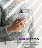 Galaxy Z Flip 7 FE / 6 / 5 / 4 / 3 | Hinge Cover Tarpaulin - Person holding a Galaxy Z Flip with a branded finger ring strap.