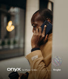 iPhone 12 Mini Case | Onyx - A man in a tan coat talks on a phone with a dark blue Onyx case while holding a coffee cup.