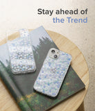 iPhone 13 Case | Fusion Design - Two clear phone cases with blue and white floral patterns resting on a forest-themed book.