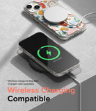 iPhone 14 Plus Case | Fusion Design - Floral clear case with MagSafe charger and phone wirelessly charging on a pad.
