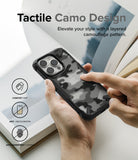 iPhone 14 Pro Case | Fusion-X - Hand holding a black phone case with a tactile camouflage pattern and three feature icons.