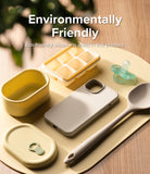 iPhone 14 Case | Silicone - Beige phone case surrounded by yellow silicone kitchenware and a baby pacifier on a wooden table.