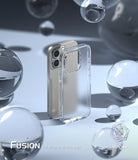 iPhone 15 Pro Max Case | Fusion - Clear phone case standing next to a gold iPhone 15 Pro Max surrounded by glass spheres.