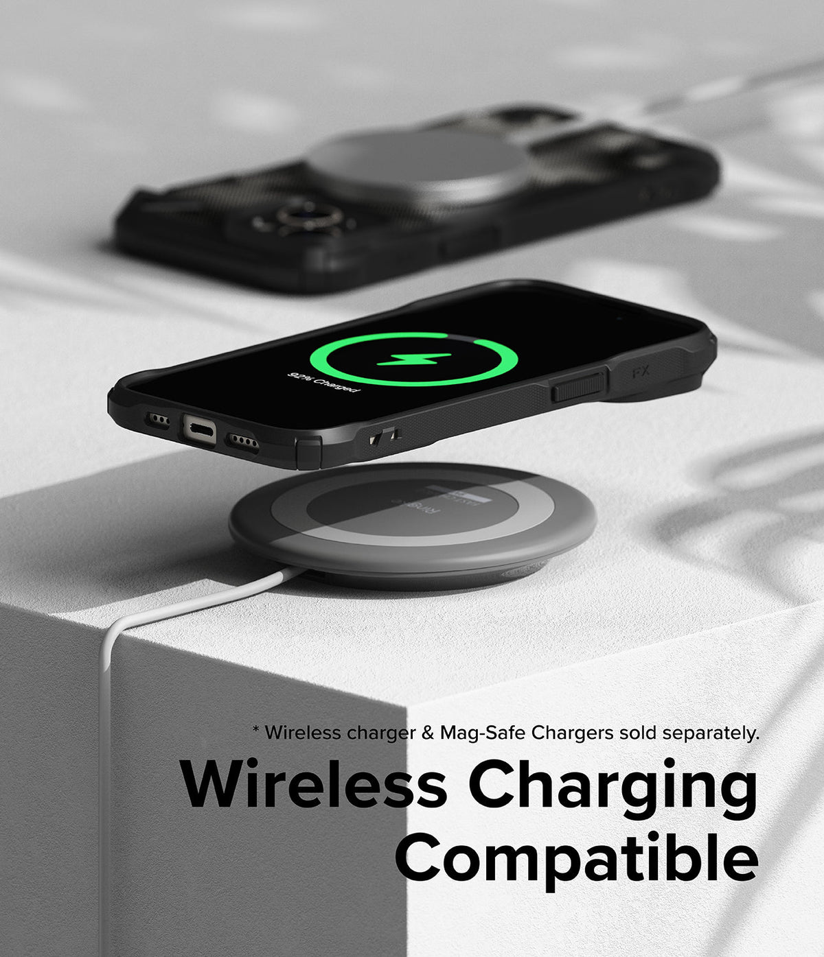 iPhone 15 Case | Fusion-X - iPhone 15 with Fusion-X case wirelessly charging on a pad, with a second case visible in the background.