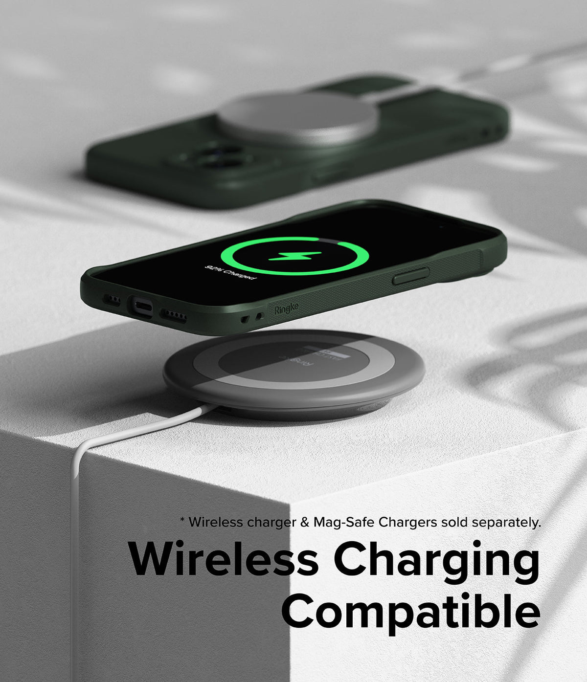 iPhone 15 Case | Onyx - Dark green iPhone 15 case wirelessly charging on a grey pad with a glowing green charging icon on screen.