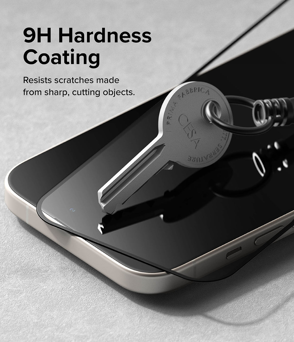 iPhone 15 Screen Protector | Full Cover Glass - iPhone 15 Screen Protector - A metal key pressing against a smartphone screen protector to demonstrate scratch resistance.