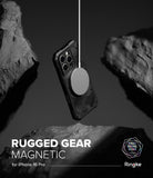 iPhone 16 Pro Case | Rugged Gear Magnetic - A rugged, camo-patterned phone case suspended by a magnetic charger amidst rocks.