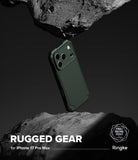 iPhone 17 Pro Max Case | Rugged Gear - Dark green phone case floating between two jagged, dark stone surfaces.